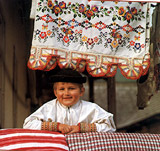A little boy from Sumiac, laughing on mothers pillow. A photography from the book The Folk Treasury of Slovakia.